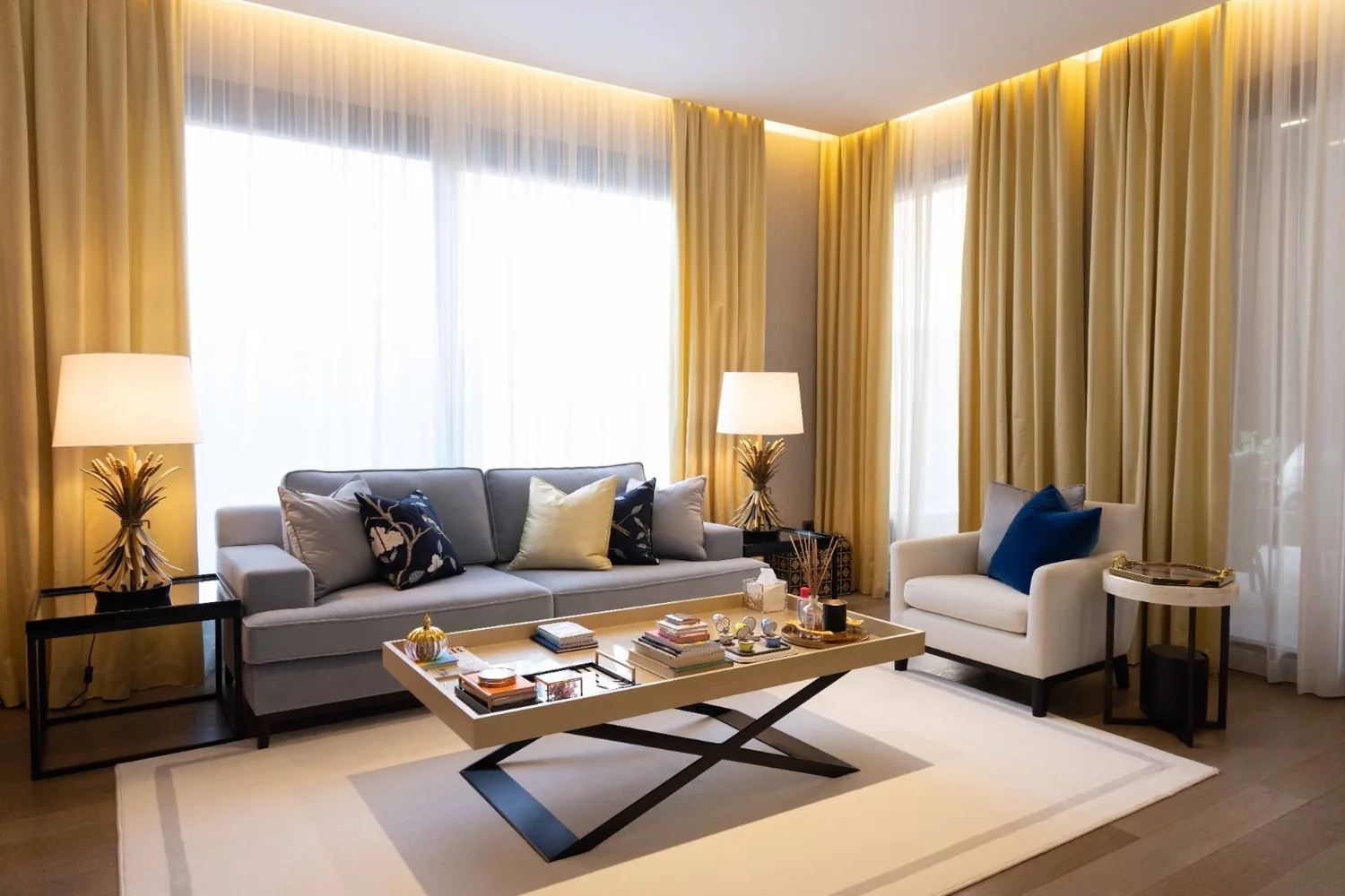 Tailored sofa and floor-length curtains against warm, dark architectural panelling